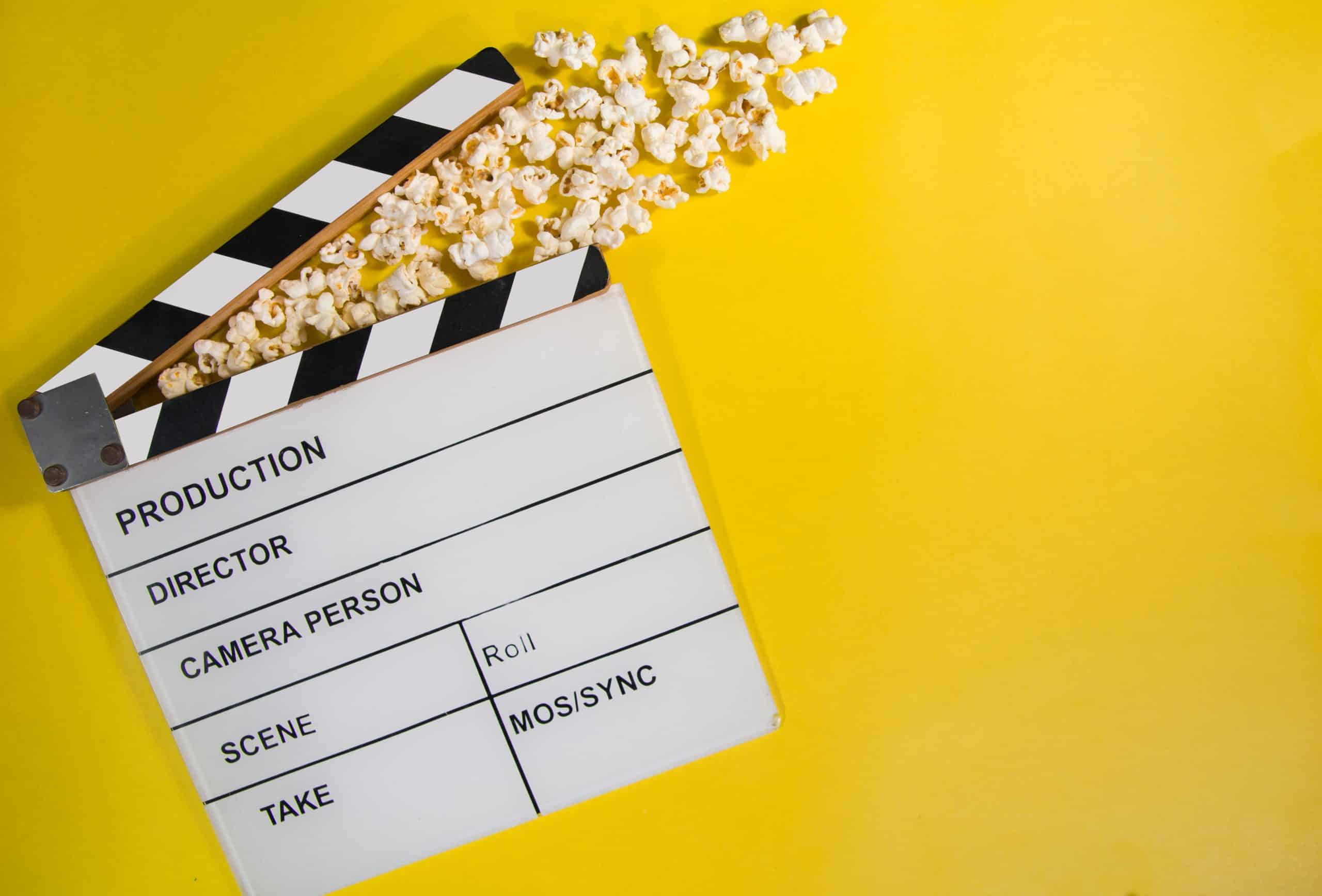 A film clapperboard with popped popcorn spilling out is set against a bright yellow background, evoking the vibrant energy of a bustling Los Angeles scene, reminiscent of an employment lawyer's drama unfolding under the city’s spotlight. Consumer Rights