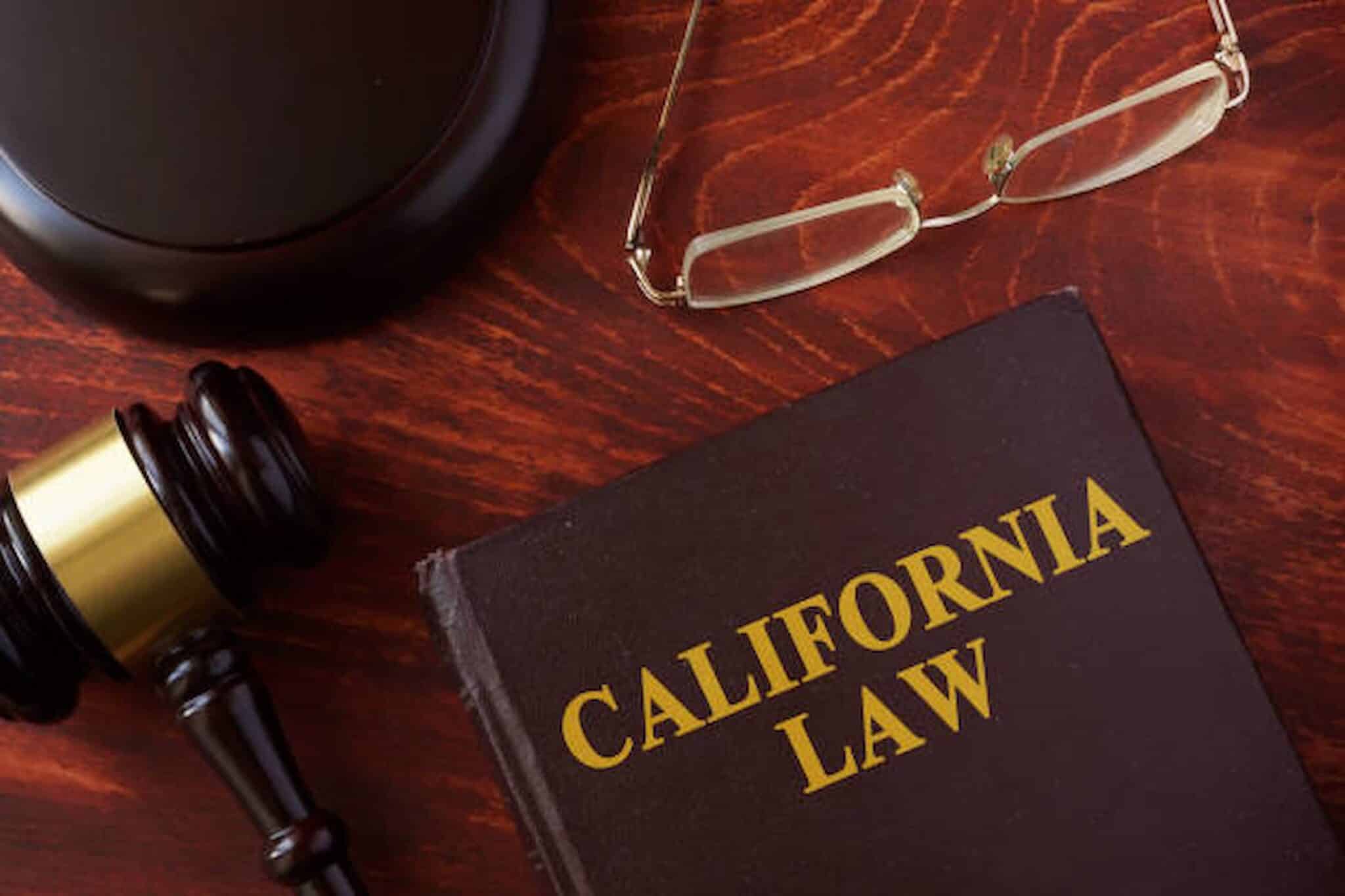 A gavel, a pair of glasses, and a book titled "California Law" rest on a wooden table, symbolizing the dedication of an employment lawyer in Los Angeles committed to justice. blog