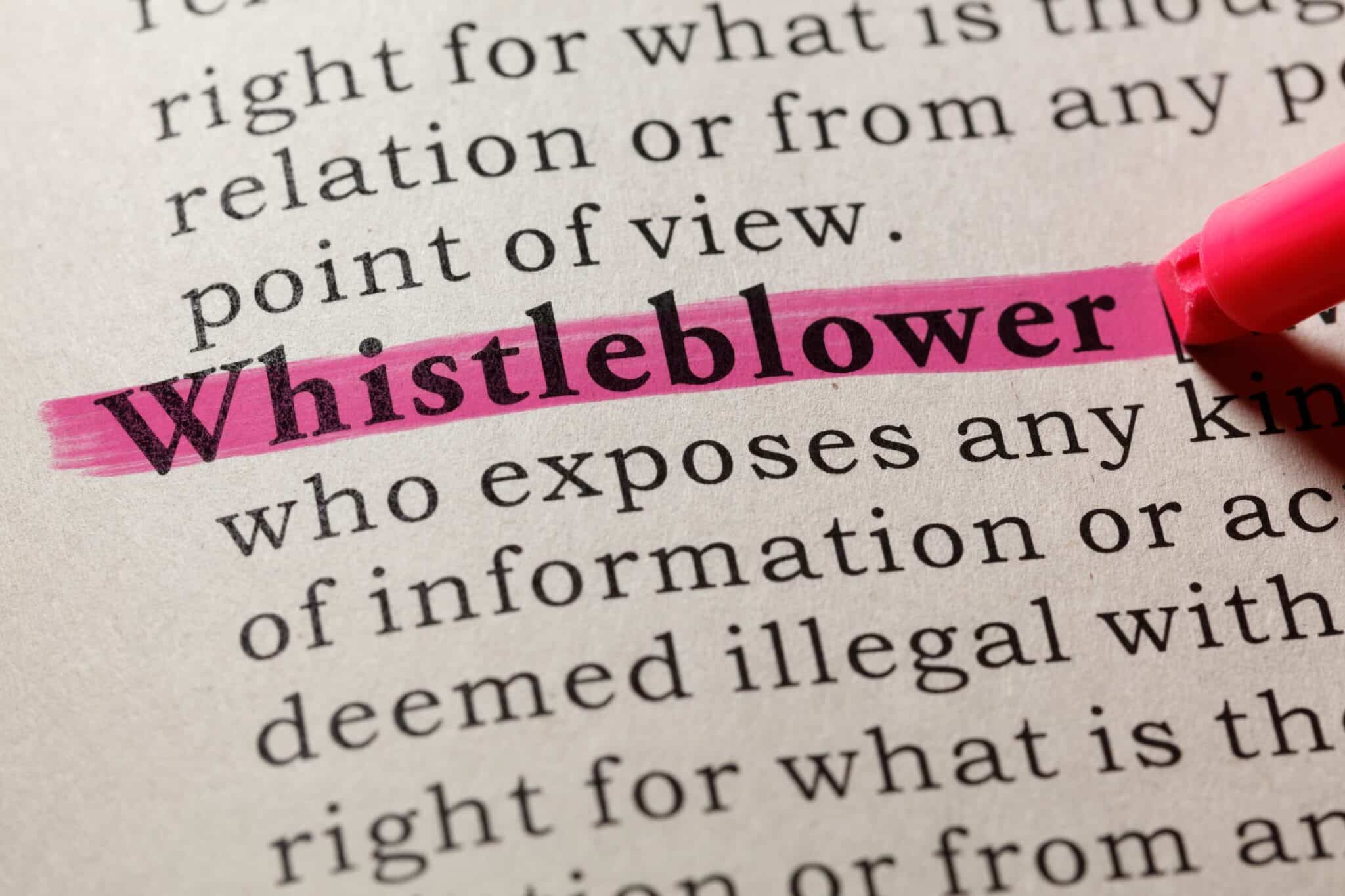 The image shows the word "Whistleblower" highlighted in pink on a printed page, a topic often handled by an experienced employment lawyer in Los Angeles. Employment Law